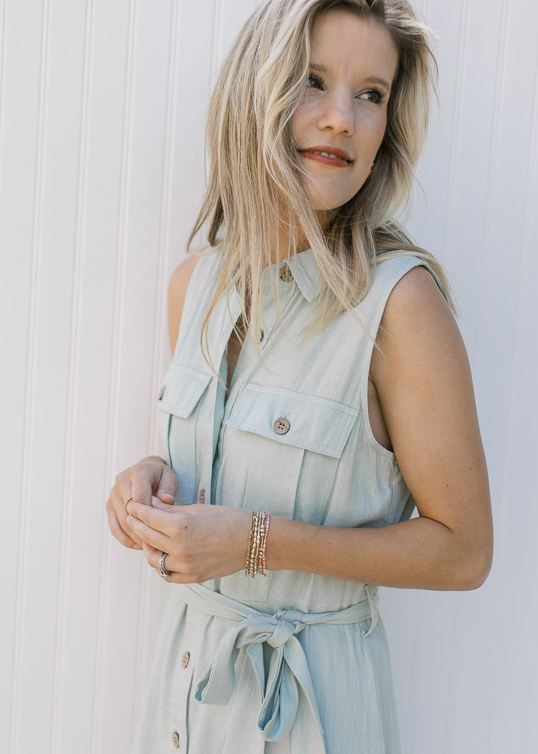 Side view of a Model wearing a soft basil maxi with button front and a tie at the waist.