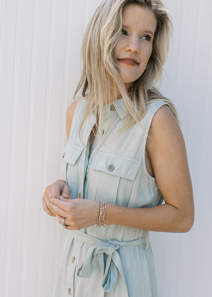 Side view of a Model wearing a soft basil maxi with button front and a tie at the waist.