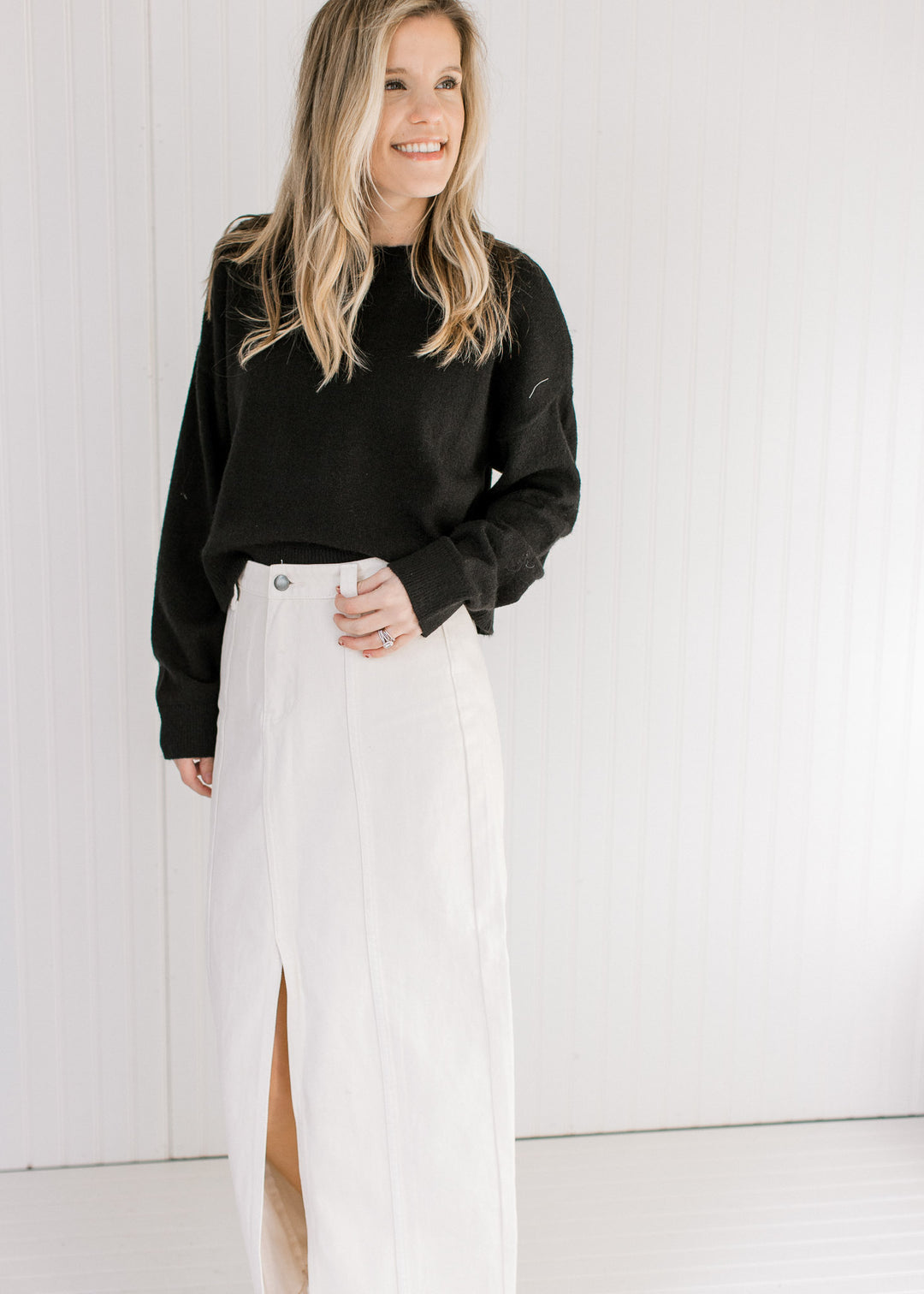 Model wearing a white maxi with a soft black sweater with a round neck and long sleeves.