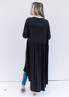 Back view of a Model wearing a black long sleeve cardigan with a duster length and an open front.