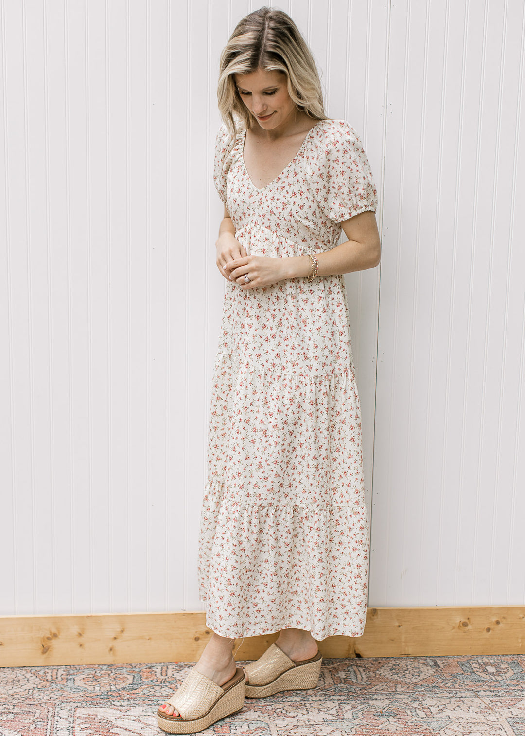 Model wearing a cream tiered maxi with pink microfloral, v-neck and bubble short sleeves.