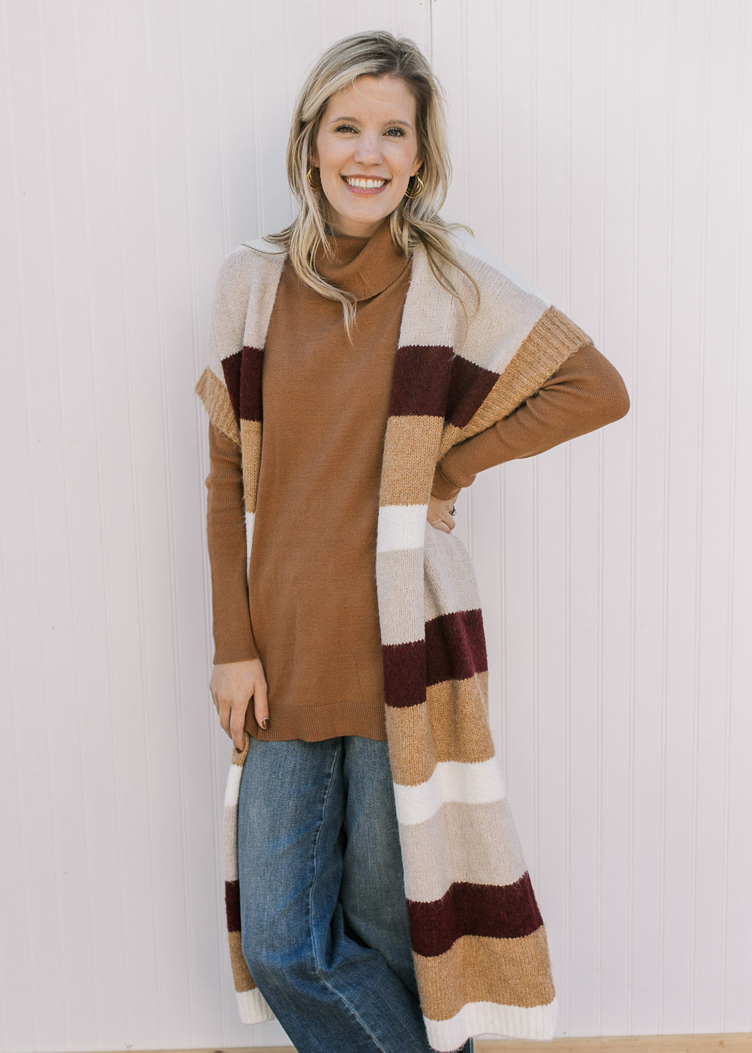 Model wearing a colorblock striped duster with a knit material and cream, camel and  maroon stripes