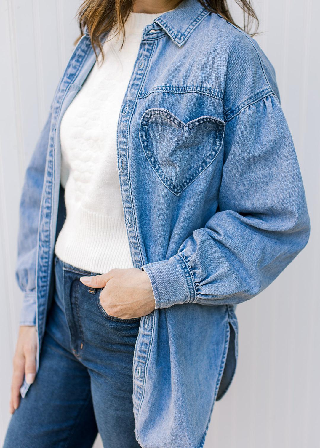 Close up of heart patch pocket on a chambray long sleeve button down top.