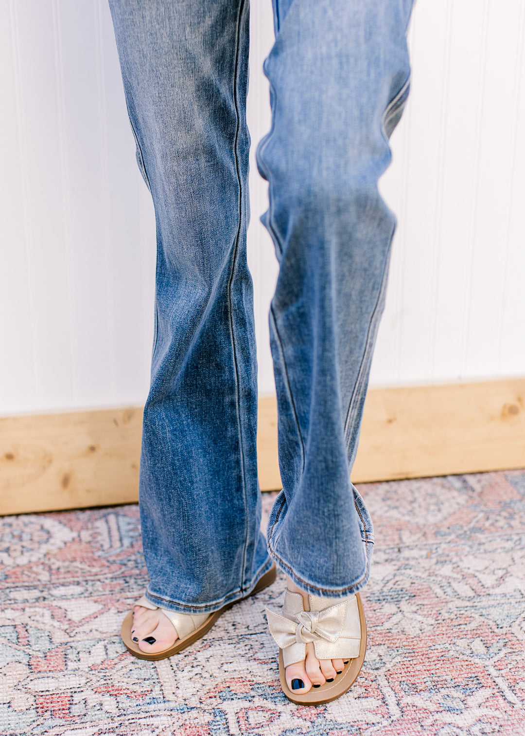 Close up of boot cut on a model wearing medium wash jeans with tummy control and a high waist.