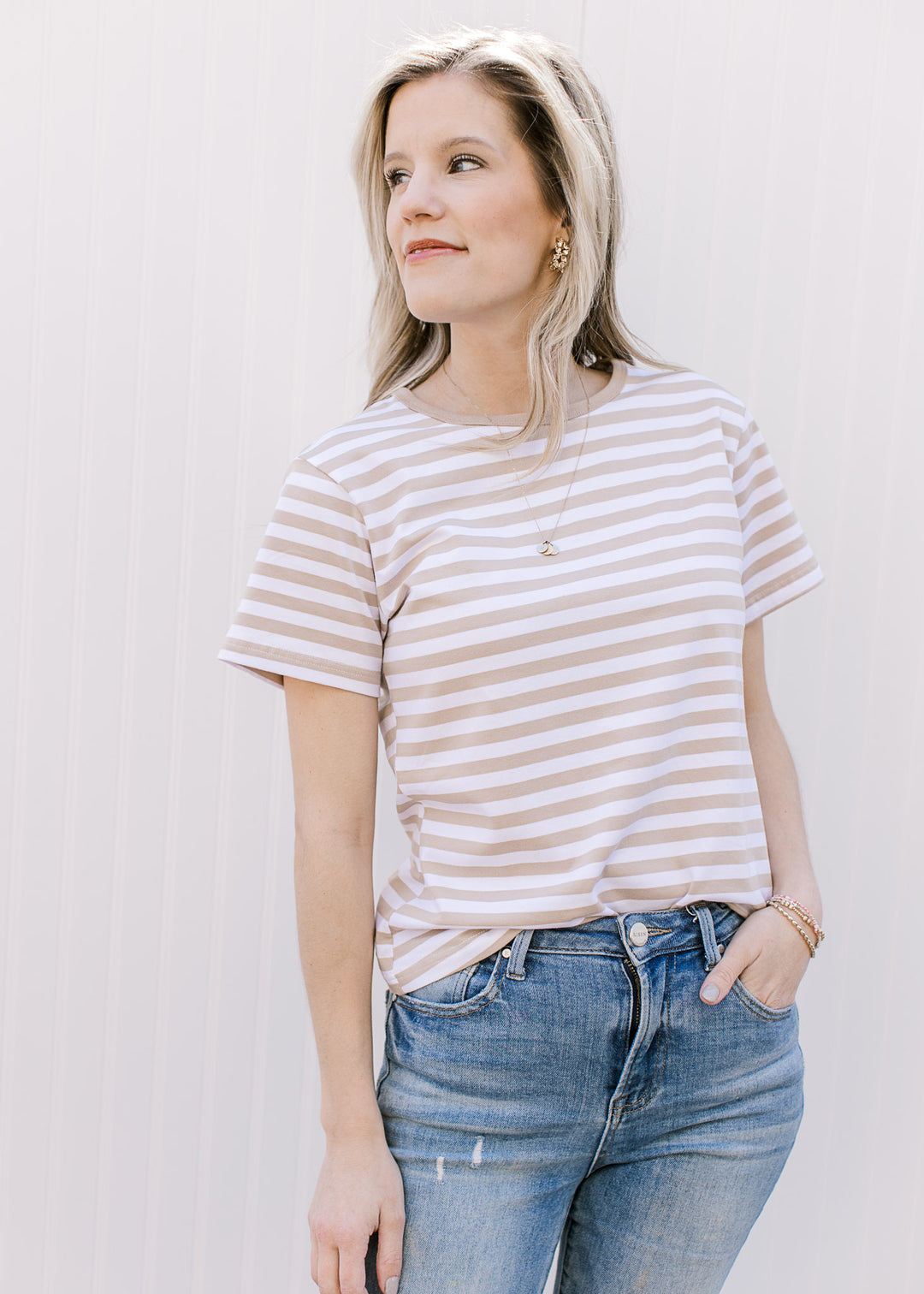 Model wearing a white tee with khaki stripes, short sleeves and a crew neck fit.