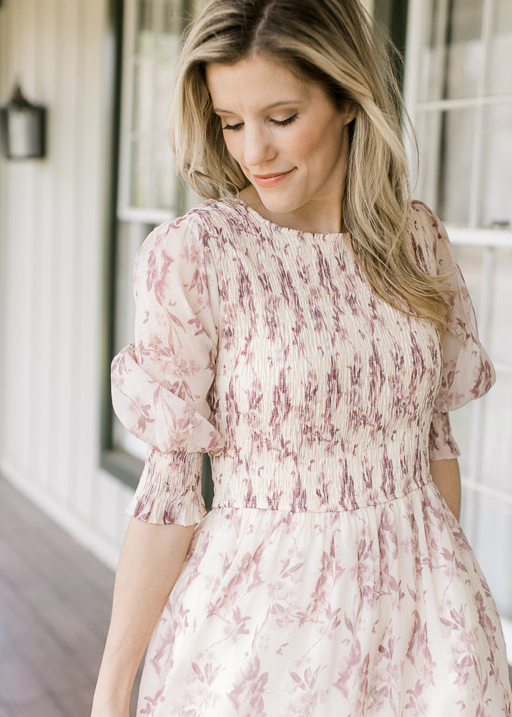 Close up of round neck and smocked bodice on a cream midi with dusty mauve floral.