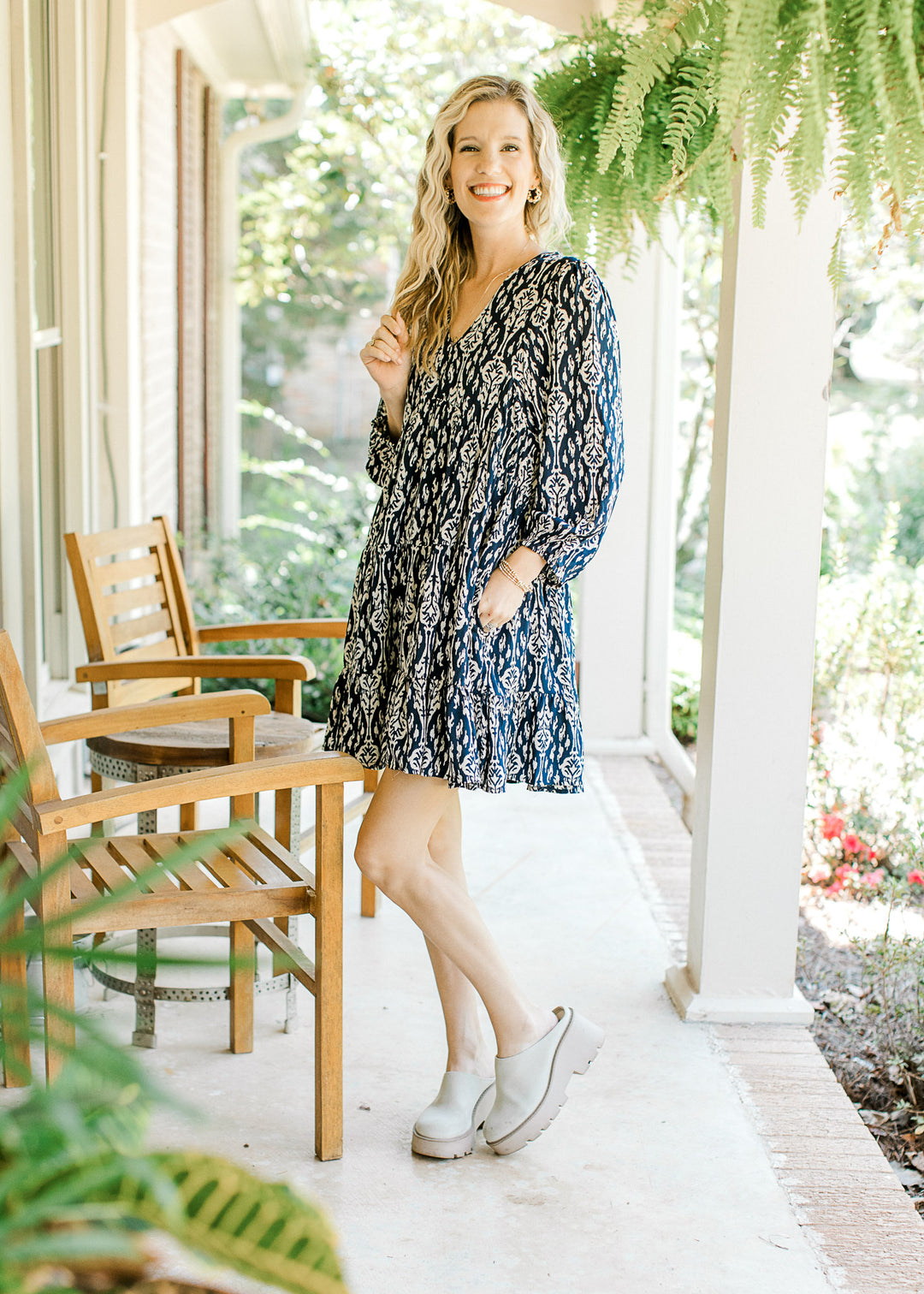 Model wearing wedges with a navy dress with taupe floral pattern, 3/4 sleeve and a v-neck.