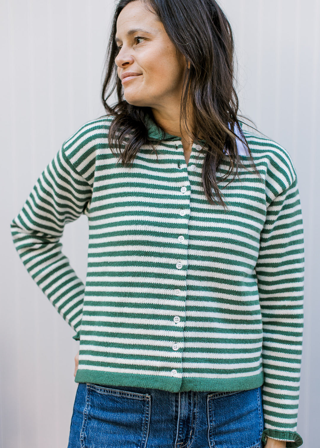 Model wearing an olive and ivory striped button up with green trim at the waist and long sleeves.