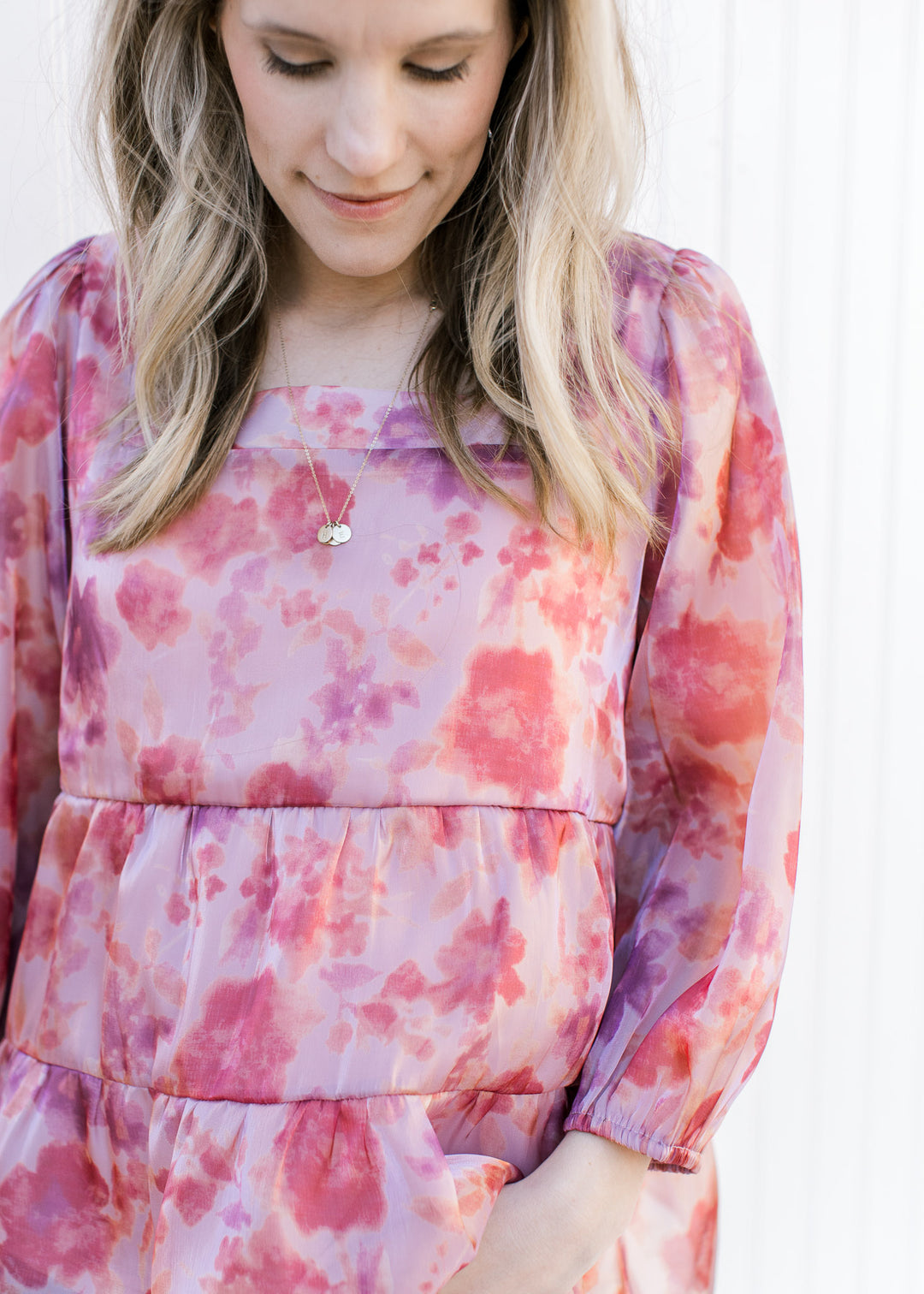 Model wearing a pink top with a blurred floral pattern, square neckline and sheer 3/4 sleeves.