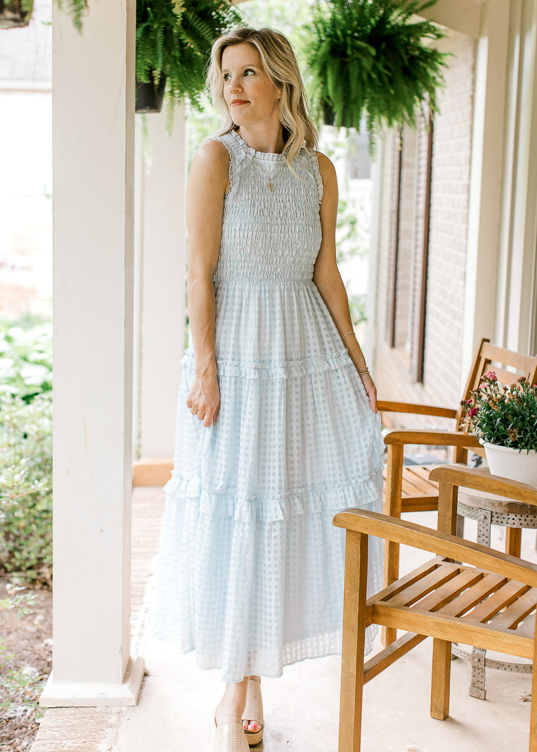 Model wearing a powder blue midi with a smocked bodice, tone on tone checks and a tiered skirt.