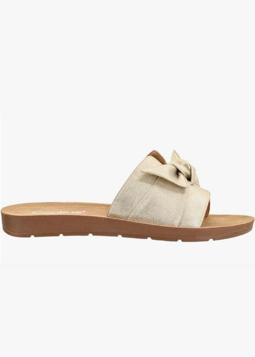 Outside view of a gold slip on sandal with a single wide strap with bow detail.