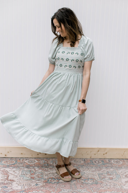 Model wearing a soft sage midi with a embroidered bodice, square neck and short sleeves.