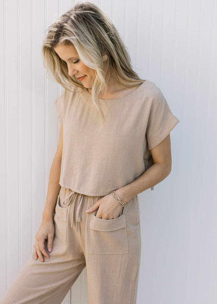 Model wearing an oatmeal set with wide leg pants with front patch pockets and a short sleeve top.