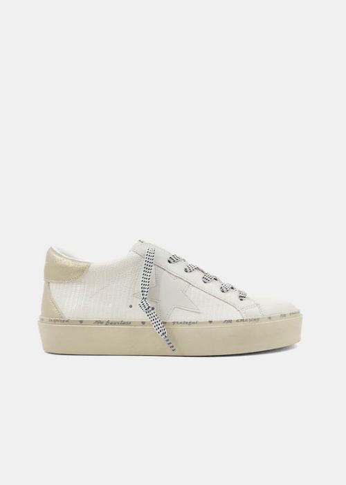 Bone colored sneakers with a star on the side and a round toe.