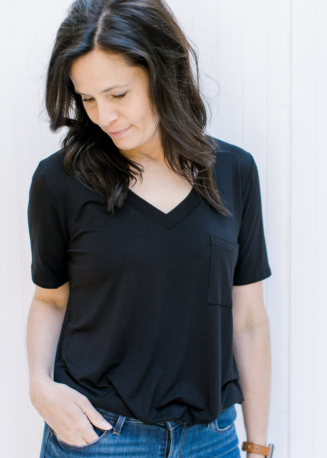 Close up of v-neck on black, bamboo, short sleeve top with a chest pocket.
