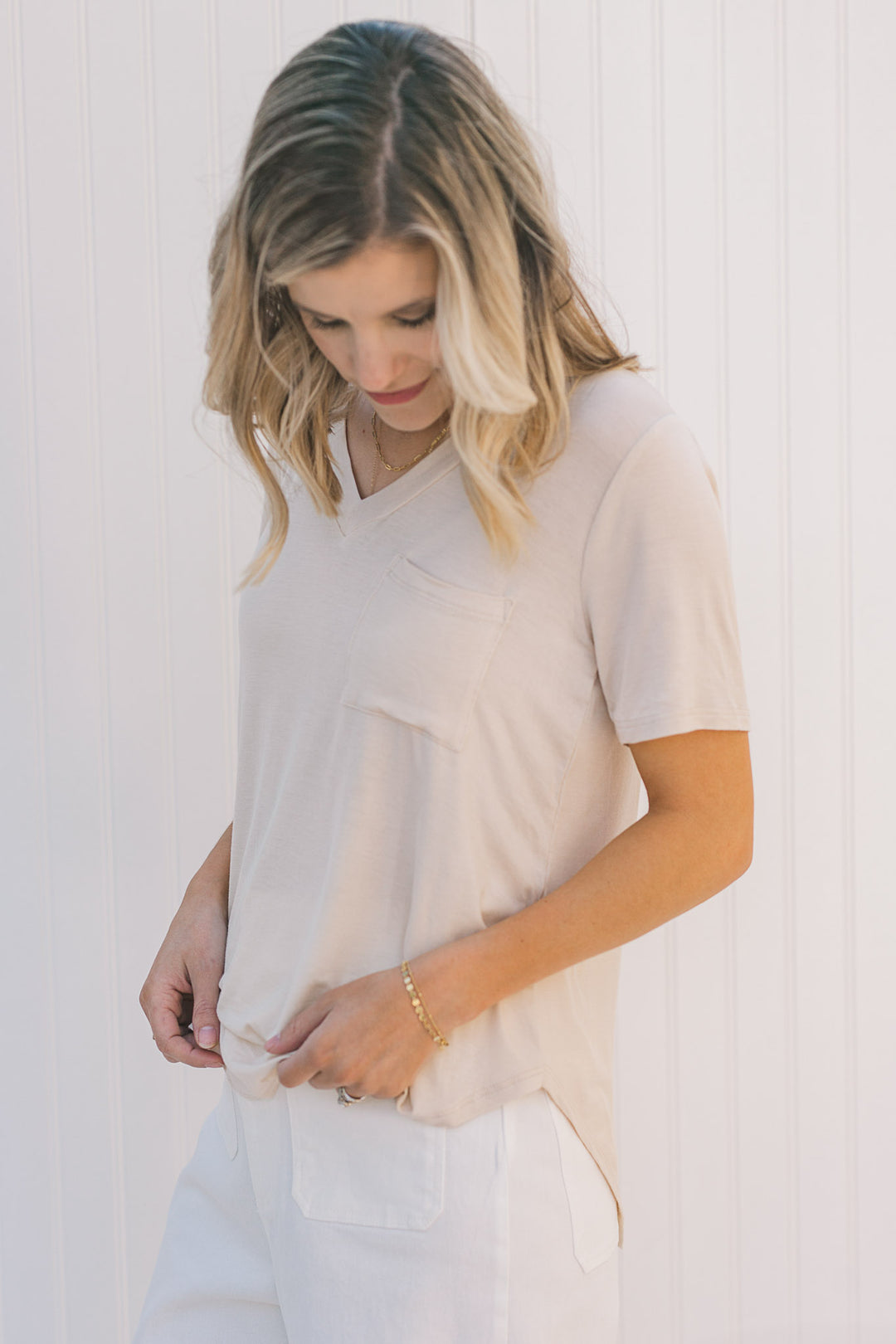 Model wearing a cream, short sleeve tee with a front pouch pocket