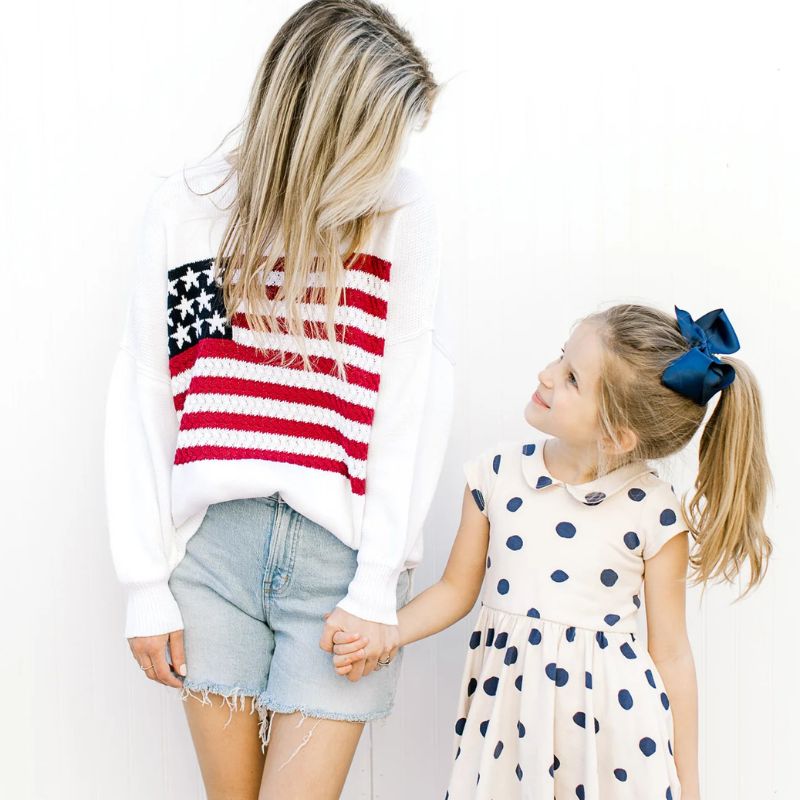 BLonde mother and daughter wearing fourth of july items.