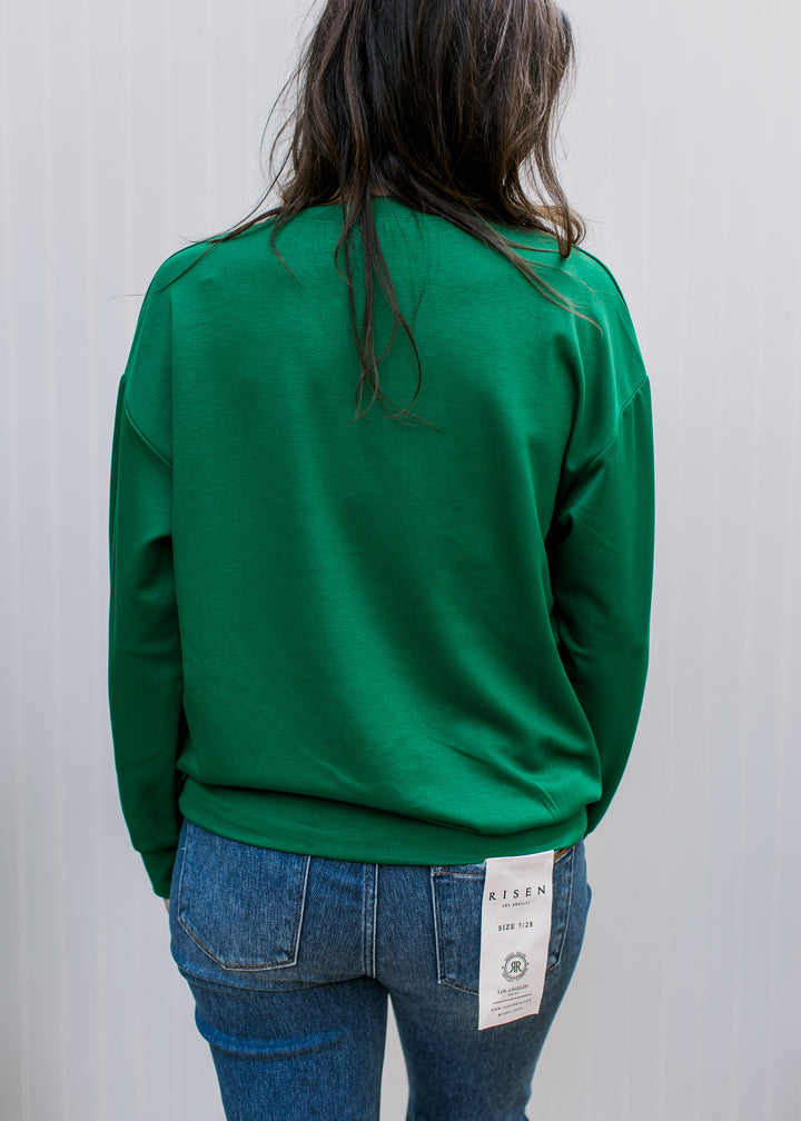  Back view of green FA LA LA pullover showing plain fabric, dropped shoulders, long sleeves and a banded hem.