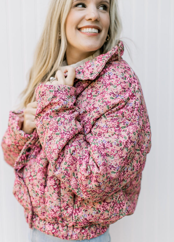 Model wearing a slightly cropped puffer with long sleeves, collar and button front. 