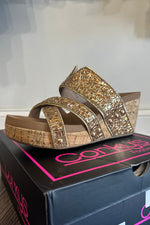 Side view of cork wedge slip on shoes with gold bead upper, cushioned footbed and 3 inch heel.