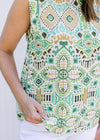 Close up of green and gold pattern on a white top, sleeveless and lightweight.