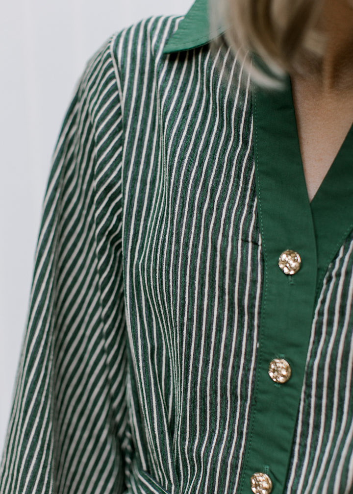 Close-up of Green Stripe Dress showing textured cream stripes, green collar and placket, and hammered gold buttons.
