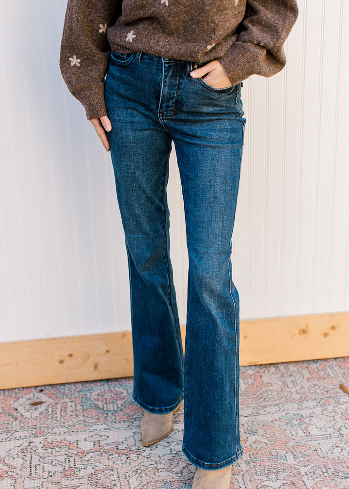 Model wearing dark wash jeans with high-waisted tummy-control fit and a bootcut leg. 