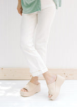 Model wearing bootcut white jeans with an amber color thread at the cuff with 5 pockets. 
