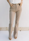 Model wearing hi-wasted, camel colored flare pants with extra tummy control. 