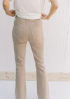 Back view of Model wearing hi-wasted, camel colored flare pants with extra tummy control. 