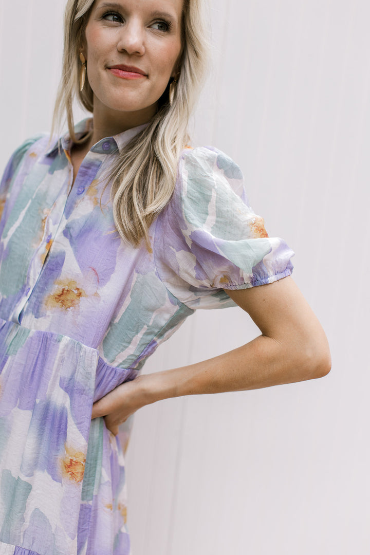 Close up of bubble short sleeves and button front on a cream dress with watercolor floral. 