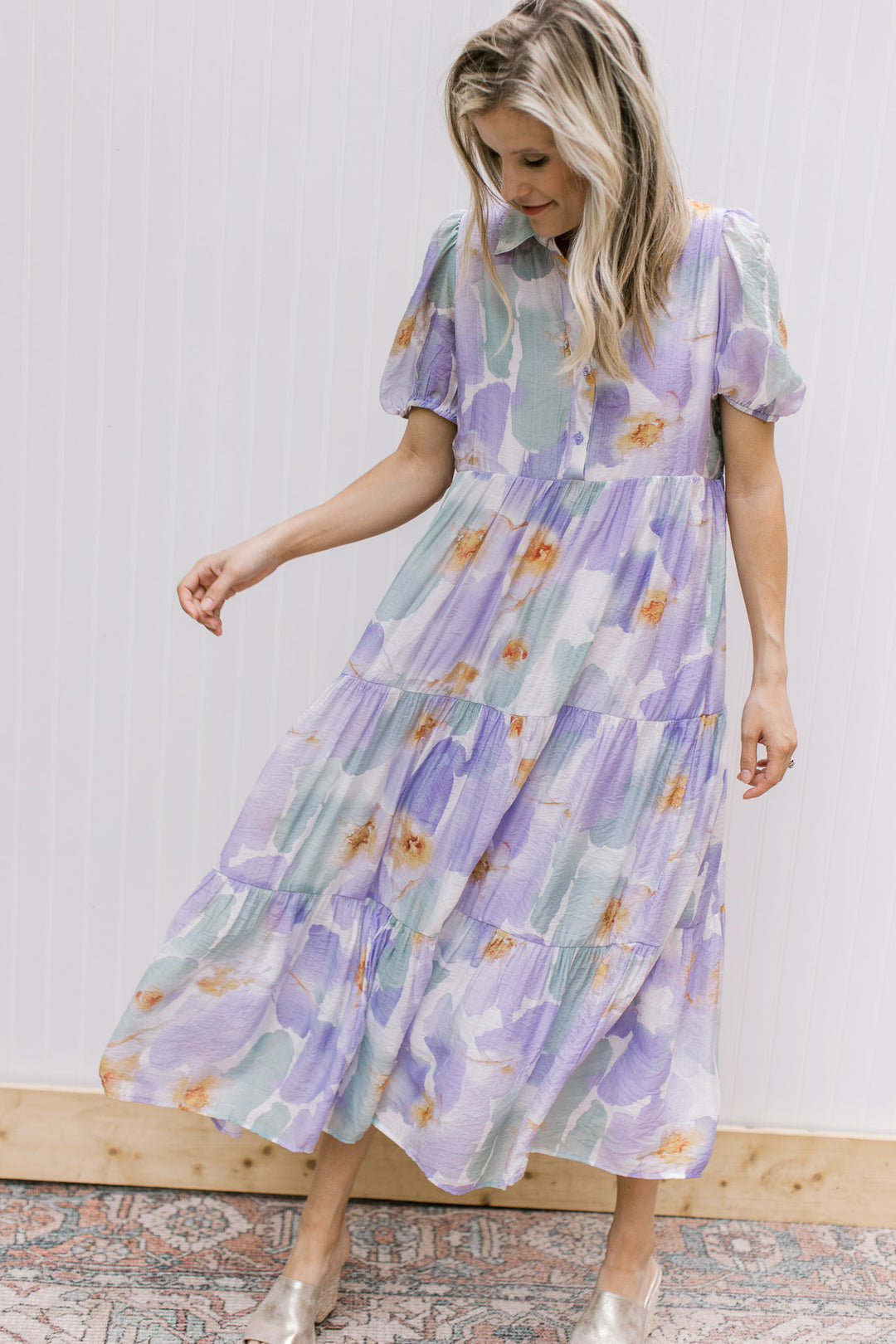 Model wearing a tiered midi with a cream background and watercolor flowers with bubble short sleeves