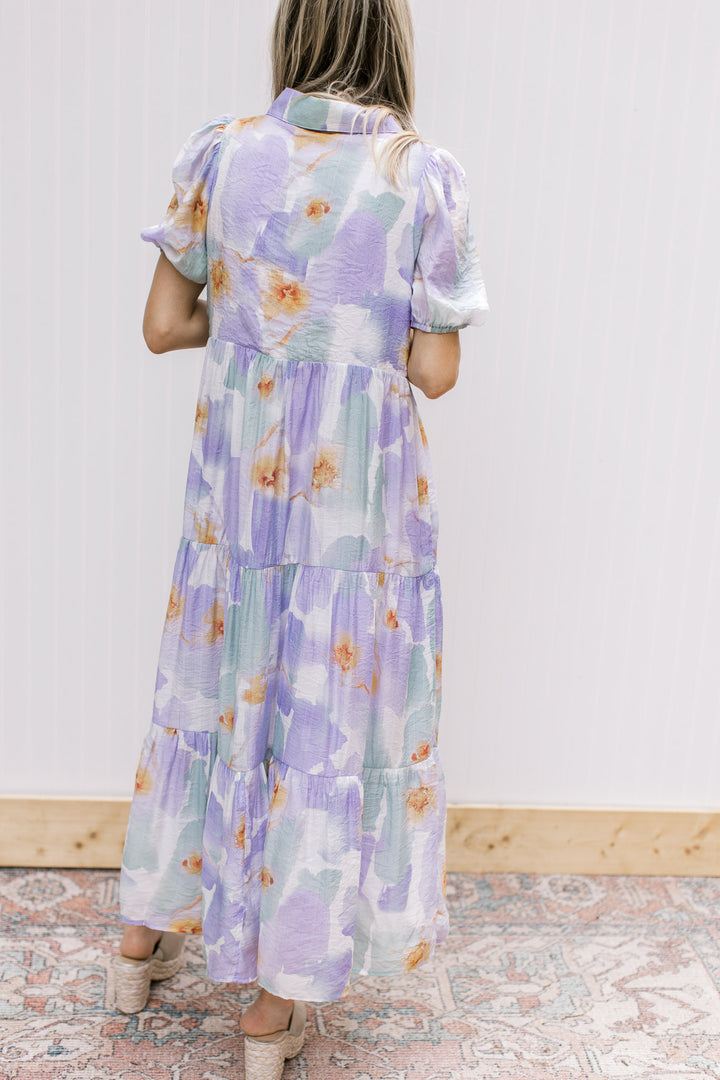Back view of Model wearing a cream dress with lavender and aqua watercolor.