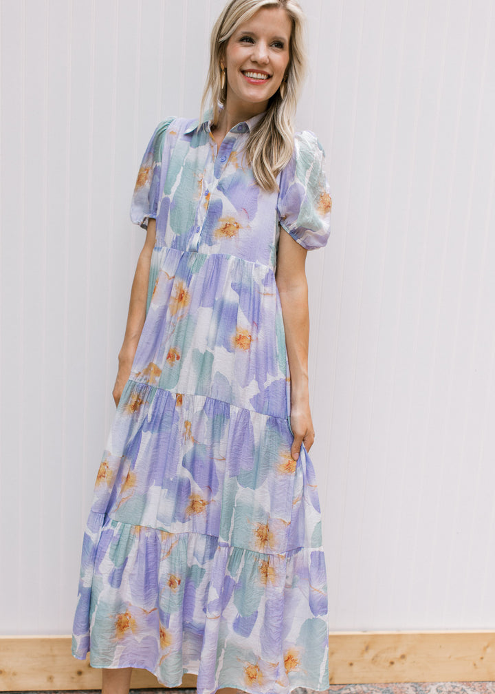 Model wearing a cream dress with lavender and aqua watercolor and a collar.