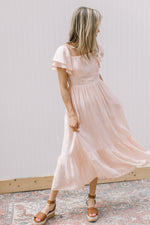 Model wearing a soft blush midi with layered short sleeves and a square neck.