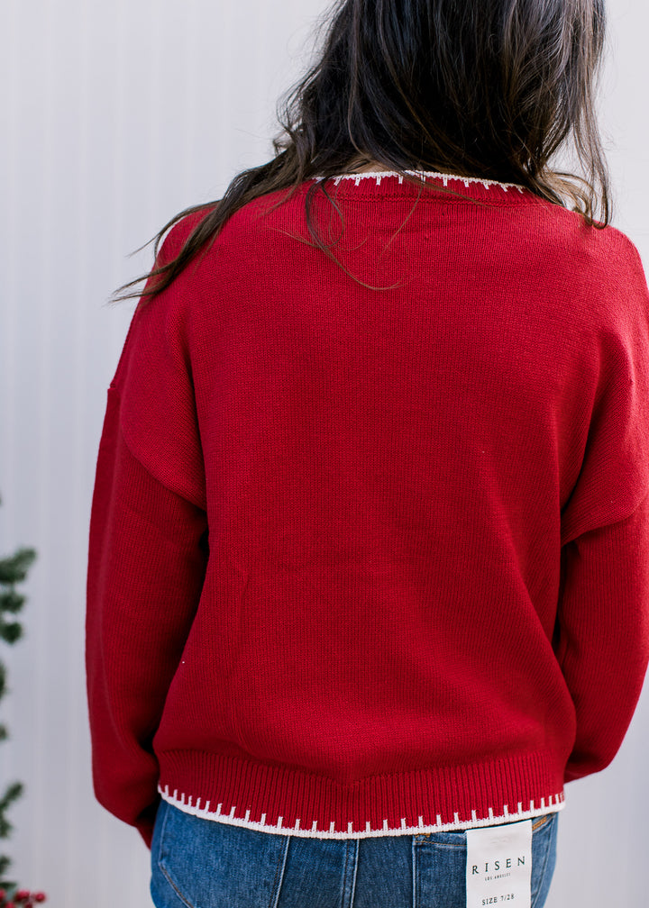 Back view of red Merry Sweater showing plain knit, dropped shoulders and cream blanket stitching at neckline and hem.