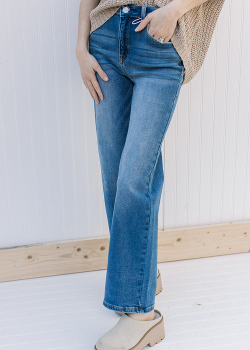Model wearing medium washed relaxed straight jeans with a high rise and no destruction.