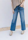 Model wearing mules  with medium washed relaxed straight jeans with a high rise.