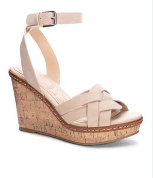 Side view of a sand color wedge sandal with a round toe, buckle closure and woven detail. 