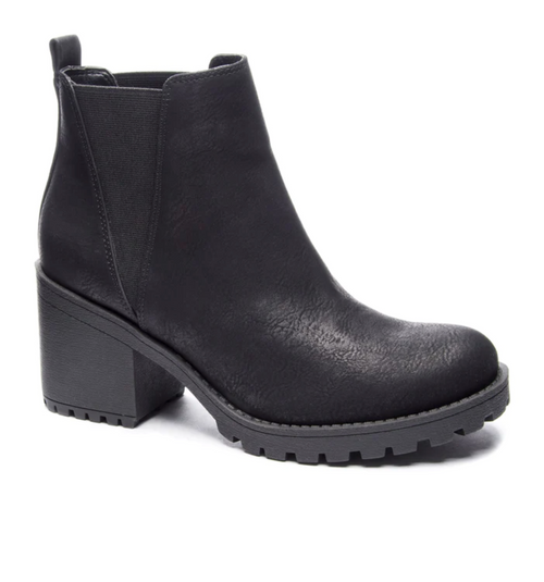 Outside view of a black bootie with a lug sole and a chunky 3” platform heel. 