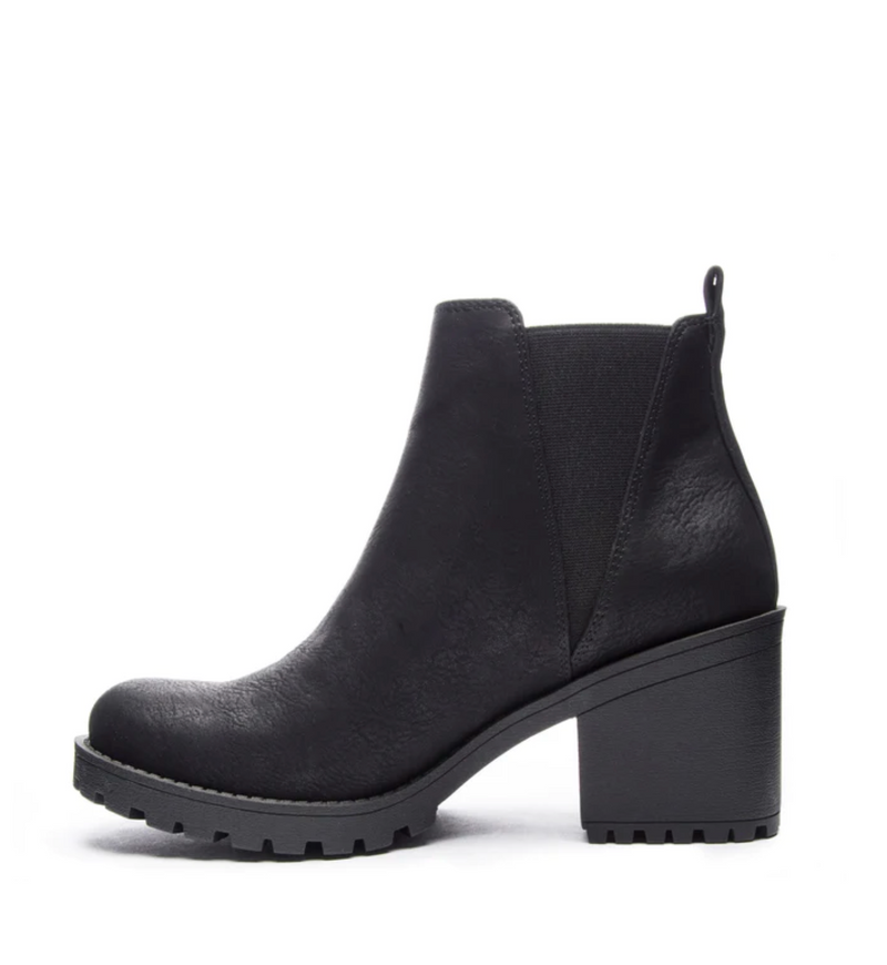 Inside view of a black bootie with a lug sole and a chunky 3” platform heel. 