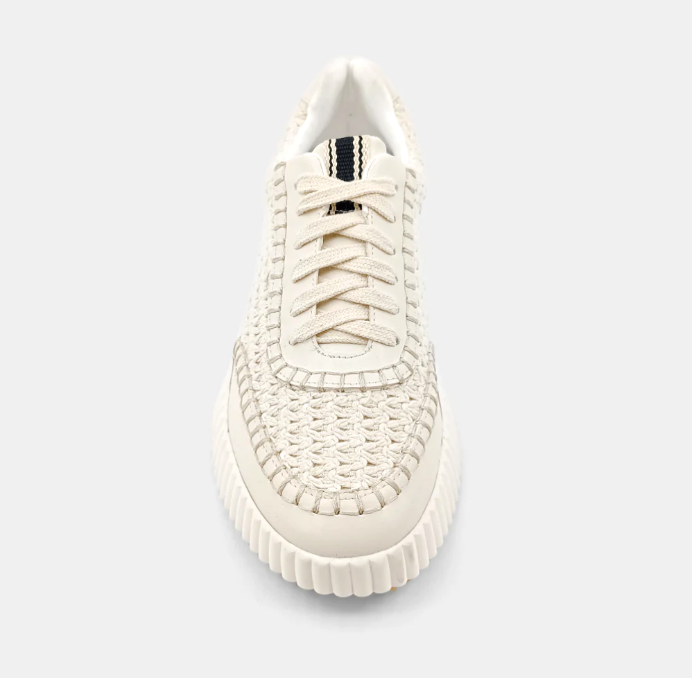 Top view of cream sneakers made of faux leather with a paneled construction and a topstitch trim.