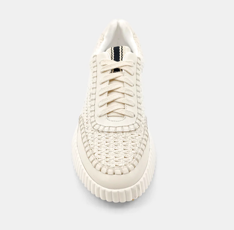 Top view of cream sneakers made of faux leather with a paneled construction and a topstitch trim.