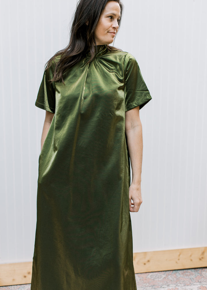 Angled view of silken olive maxi dress showing gathered high neckline, short sleeves and loose, lustrous drape.