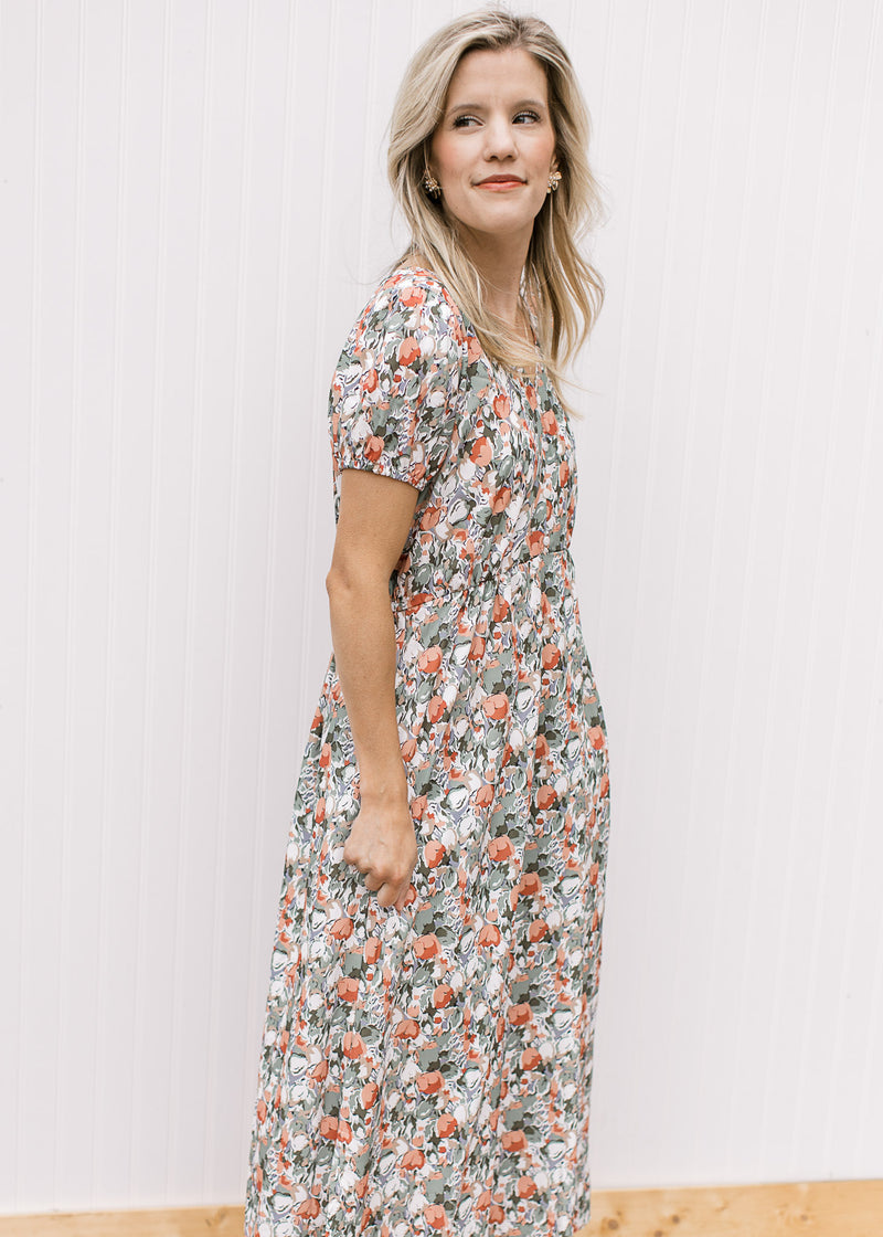 Model wearing a white midi with sage, peach and rust tulips, v-neck and short sleeves. 