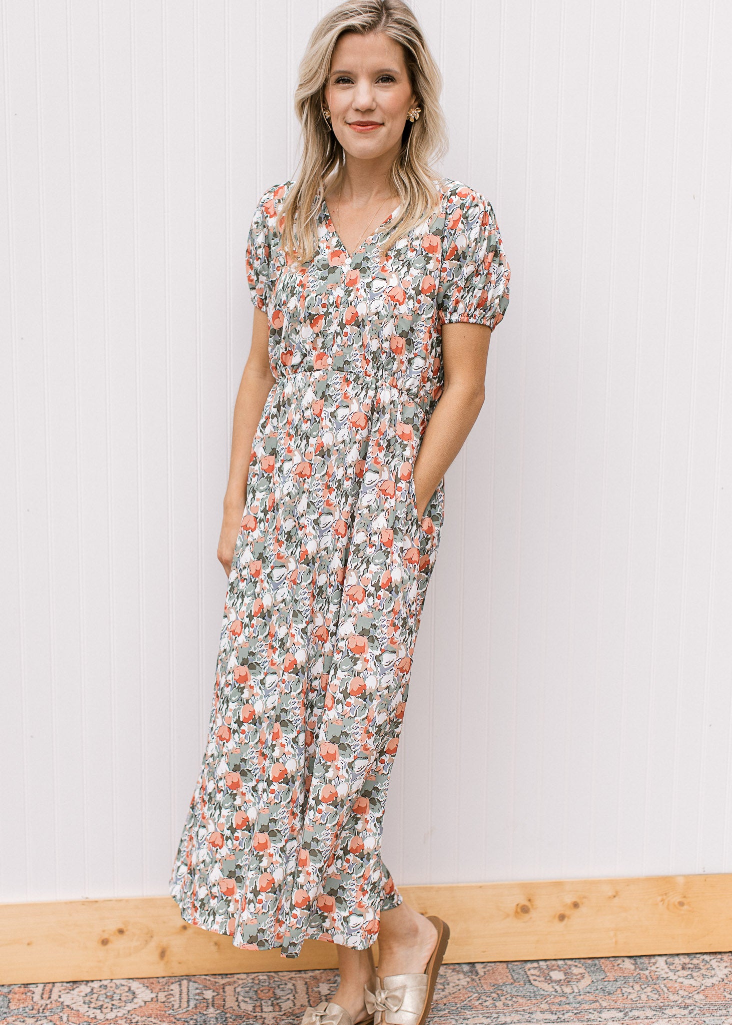 Model wearing sandals and a white midi with sage, peach and rust tulips, v-neck and short sleeves. 