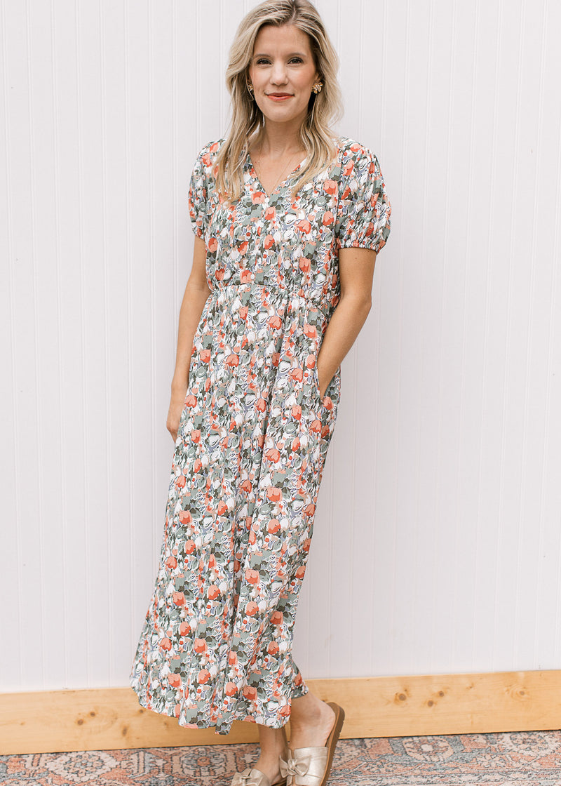 Model wearing sandals and a white midi with sage, peach and rust tulips, v-neck and short sleeves. 