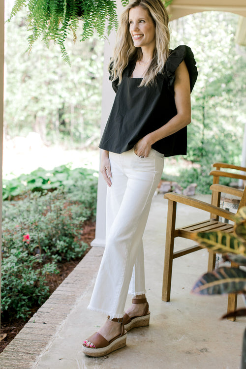 Model wearing white crop jeans with a raw hemline and tummy control.