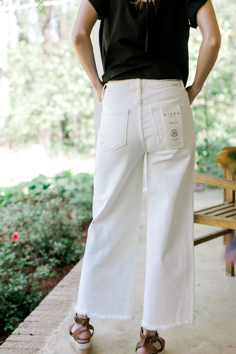 Back view of Model wearing white crop jeans with a raw hemline and tummy control.