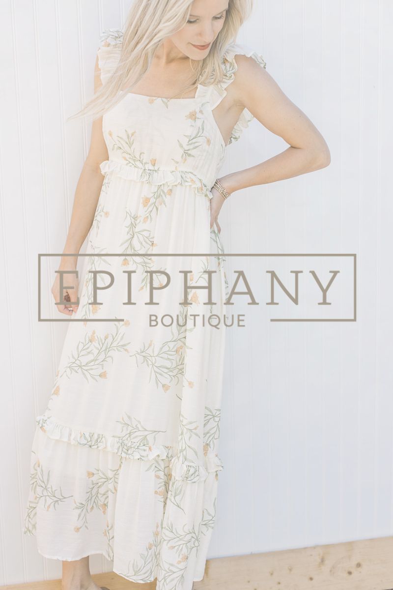 Blonde model with Epiphany Boutique logo across cream dress